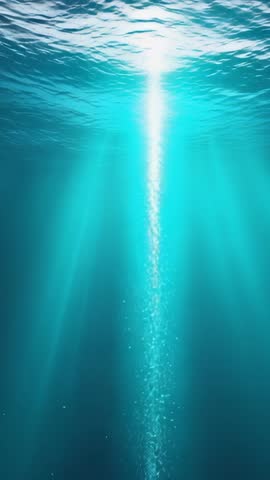 Vertical underwater video streaming sunbeams through turquoise ocean with rising bubbles