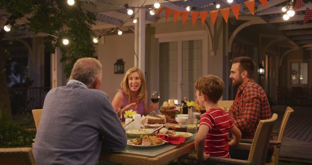 Happy caucasian father, son and grandparents talking at family dinner table in garden - Download Free Stock Photos Pikwizard.com