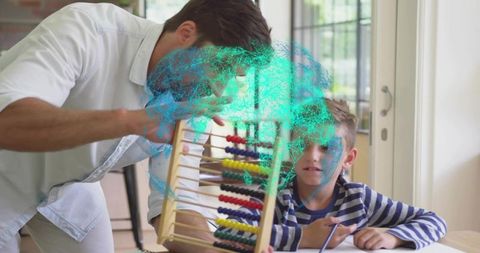 Mid-adult tutor mentoring schoolboy teaching counting with wooden abacus at sunlit desk