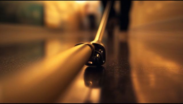 Metal slider rail gliding on reflective floor under warm light