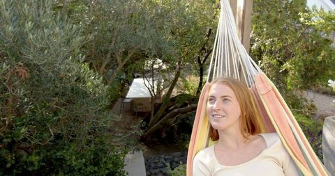 Woman Relaxing in Hammock Amidst Serene Garden