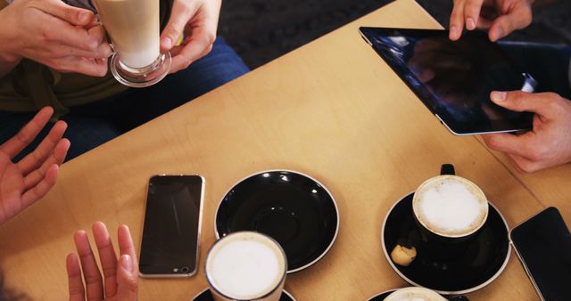 Casual Meeting with Coffee and Technology Devices at Cafe Table - Download Free Stock Images Pikwizard.com