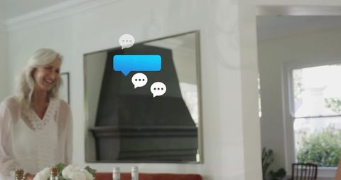 Smiling senior woman in bright cozy living room with chat bubbles and mirror reflection