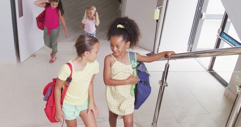 Happy Diverse Schoolgirls Socializing on Staircase