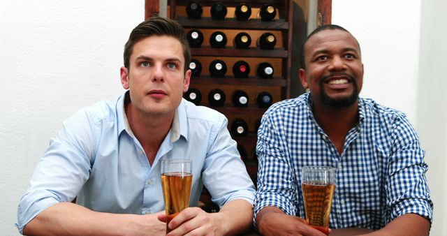 Two Friends Enjoying Beer in Front of Wine Rack - Download Free Stock Images Pikwizard.com