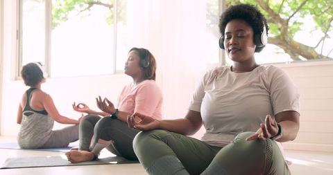 African American Women Meditating in Yoga Studio