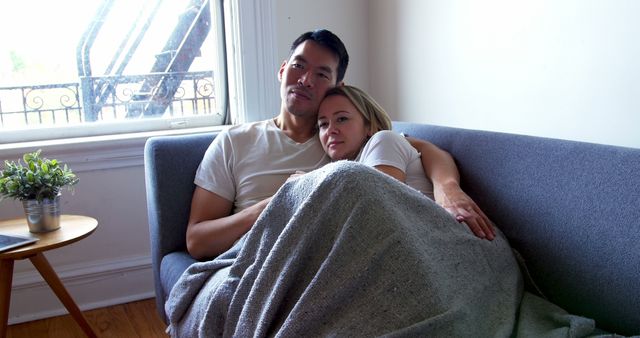 Interracial Couple Cuddling Together on Sofa at Home - Download Free Stock Images Pikwizard.com