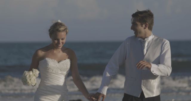 Newlywed Couple Walking on Beach Hand in Hand - Download Free Stock Images Pikwizard.com