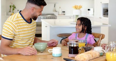 Father and Daughter Enjoying Breakfast in Modern Kitchen