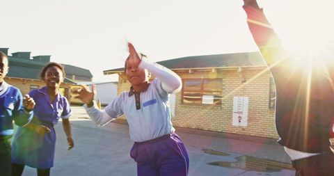 Joyful Schoolchildren Play Ball in Sunlit Schoolyard