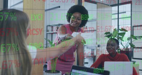 Businesswomen Collaborating in Modern Workspace with Financial Data Overlay - Download Free Stock Images Pikwizard.com