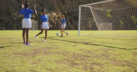 Youth soccer team celebrating goal in sunny park