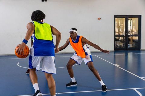 Young male athletes intense basketball game in indoor gym