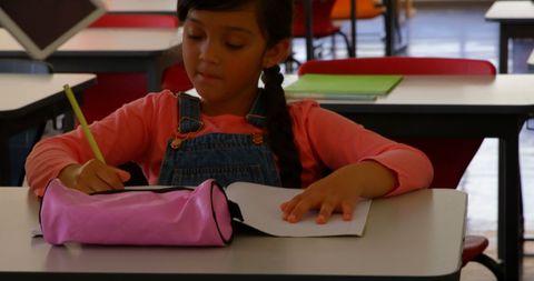 Young Girl Concentrating on Homework in Classroom