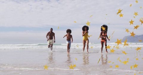 Family running through waves with golden stars celebration
