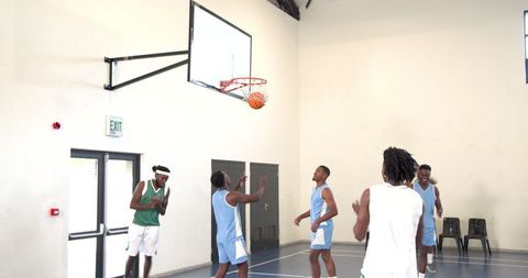 Young Male Basketball Players Celebrating Successful Basket in Gym