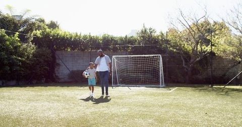 Father and Son Bonding on Backyard Soccer Turf on Sunny Day