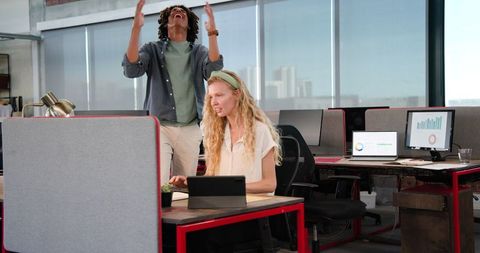 Colleagues Laughing Sharing Digital Progress in Vibrant Office