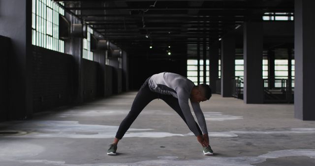 Man Stretching in Abandoned Warehouse - Download Free Stock Images Pikwizard.com