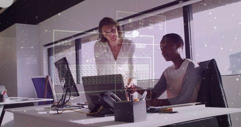 Professional women collaborating on office project at modern workstation