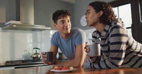 Happy Diverse Couple Enjoying Coffee Together in Modern Kitchen