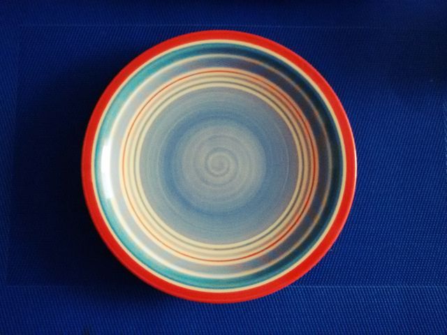Colorful Striped Ceramic Plate on Blue Background - Download Free Stock Photos Pikwizard.com