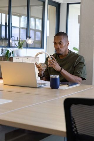 African american professional testing headphones at modern coworking desk