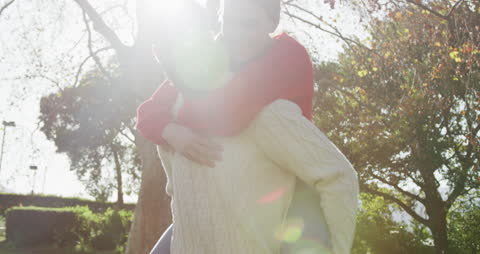 Joyful Couple Embracing in Sunlit Autumn Garden