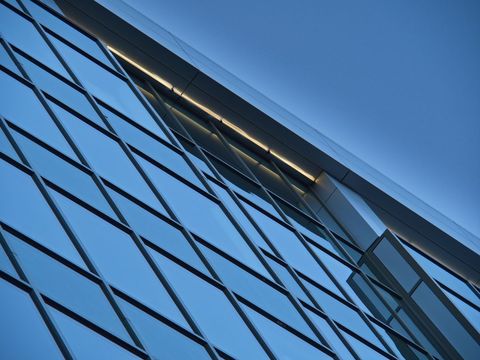 Modern glass facade reflecting sky architecture