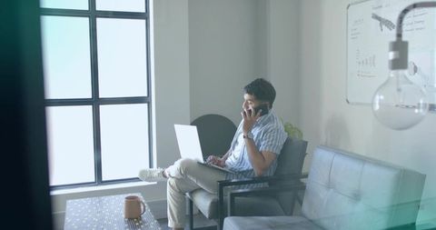 Businessman Multi-tasking in Modern Lounge Workspace