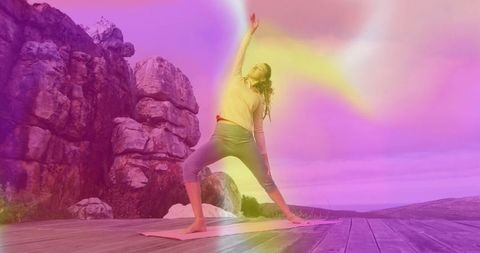 Woman practicing outdoor yoga on colorful cliffside