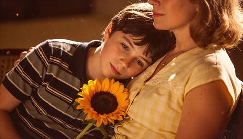 Sunflower comfort boy leaning on mother holding sunflower gentle family moment