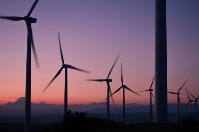 Wind turbines captured against a beautiful sunset backdrop, highlighting renewable energy and sustainability. Suitable for articles, environmental campaigns, eco-friendly product promotions, and educational materials on clean energy.