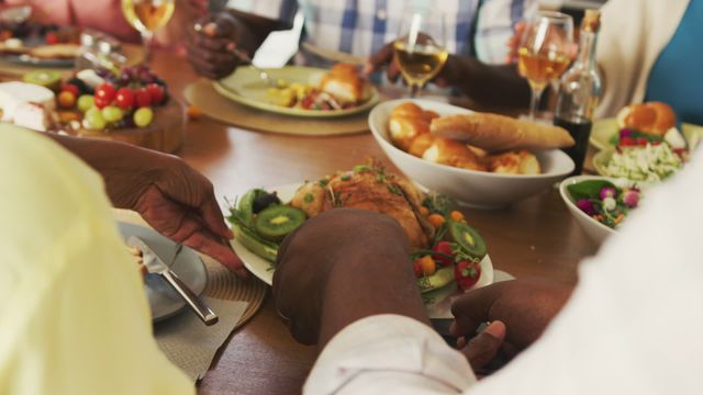 Senior friends from diverse backgrounds are enjoying a communal dinner with wine, engaging in conversation and celebrating together at a retirement home. This video can be used for articles on healthy aging, active retirement, body inclusivity, or promoting diversity and inclusivity in social gatherings.