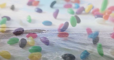 Surreal jelly beans floating above ocean waves