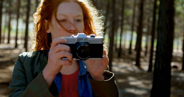 Woman with Red Hair Using Film Camera in Forest - Download Free Stock Images Pikwizard.com