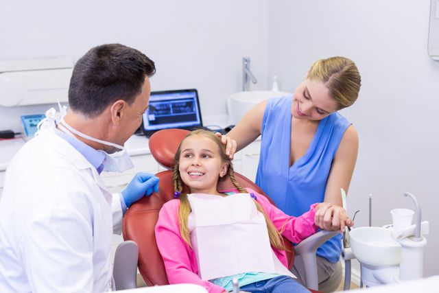 Dentist interacting with young patient at dental clinic