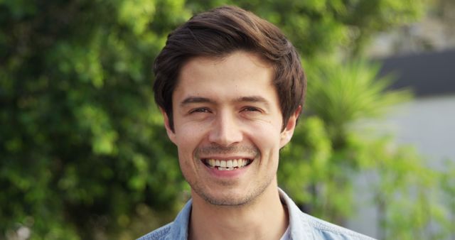 Smiling Young Man Outdoors with Greenery in Background - Download Free Stock Images Pikwizard.com