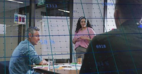 Female presenter leading team presentation with flip chart and data overlay in office
