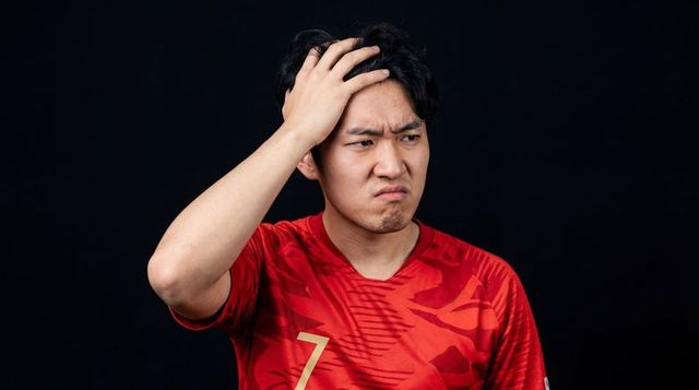 Asian male athlete expressing frustration wearing red number 7 jersey, head scratching