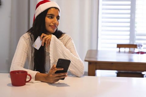 Festive online shopping with santa hat and smartphone