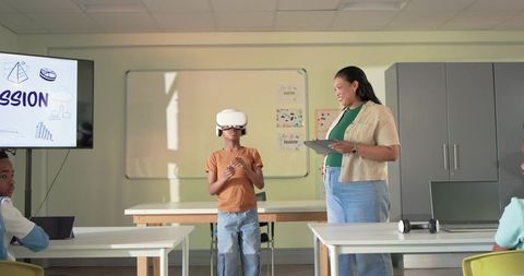 Teacher guiding student using VR headset for immersive STEM lessons in classroom