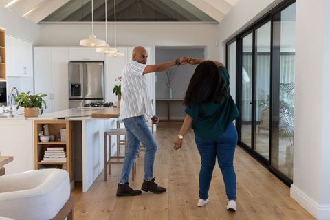 African american couple dancing in spacious open-plan kitchen, joyful home moments