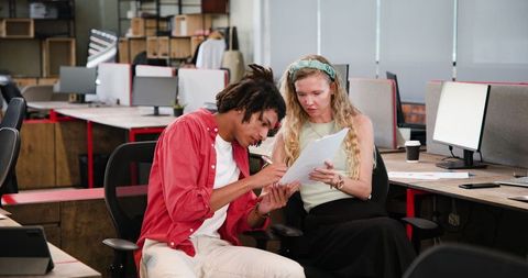 Colleagues Discussing Project in Modern Open Office Setting