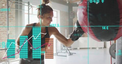 Female athlete punching heavy bag with augmented reality fitness analytics in brick studio