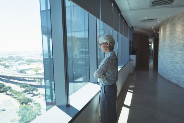 Thoughtful businesswoman standing by window in office