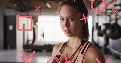 Confident Young Woman with Jump Rope in Gym with Abstract Graphics