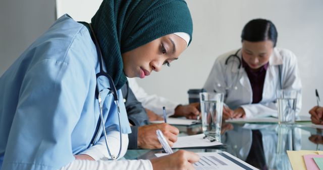 Focused Nurse Reviewing Medical Documents in Conference Room - Download Free Stock Images Pikwizard.com