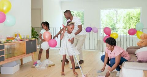 Family Joyfully Tidying Up After Home Celebration