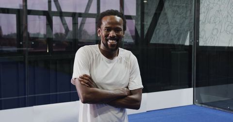 Confident athlete smiling indoor padel court standing